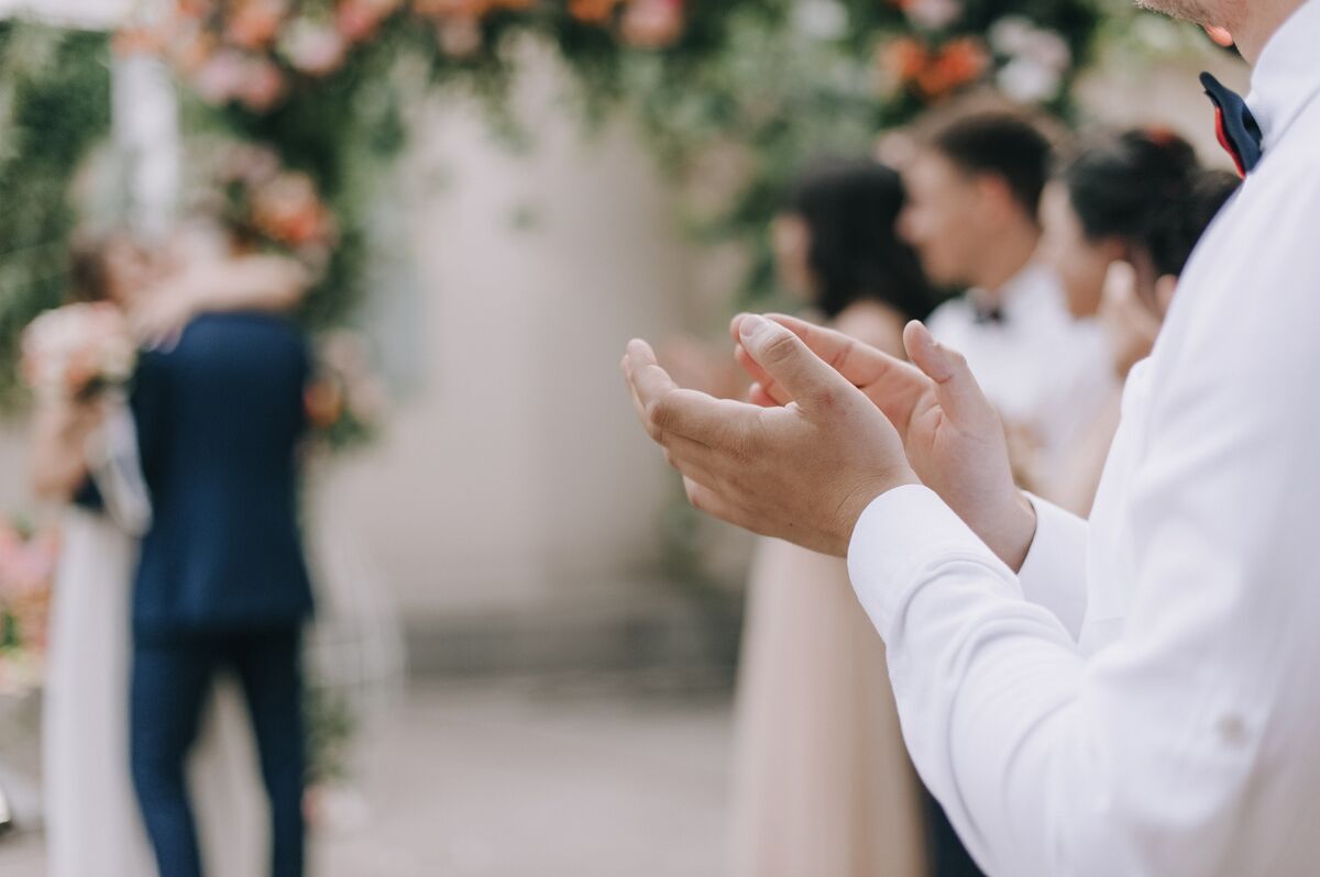 A couple walking back down the aisle as guests applaud